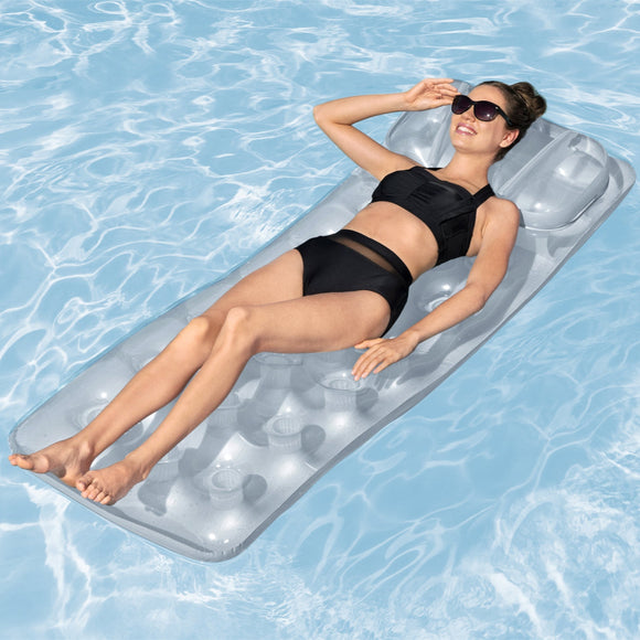 Woman lying on a clear inflatable pool raft in a pool.