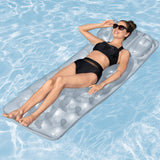 Woman lying on a clear inflatable pool raft in a pool.