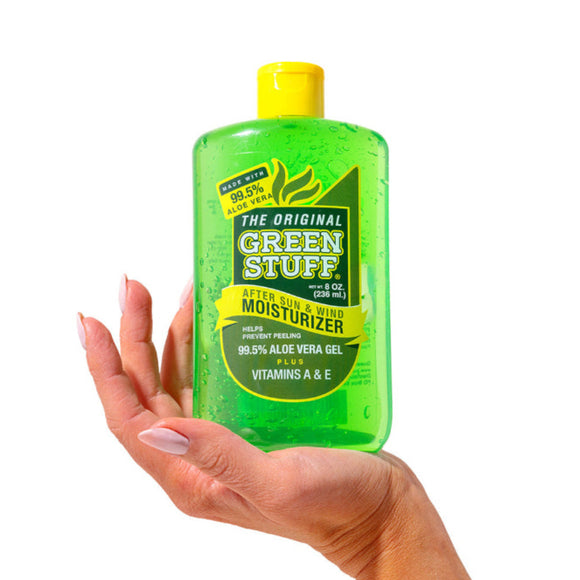 Hand holding a bottle of 'The Original Green Stuff' after sun moisturizer on a white background